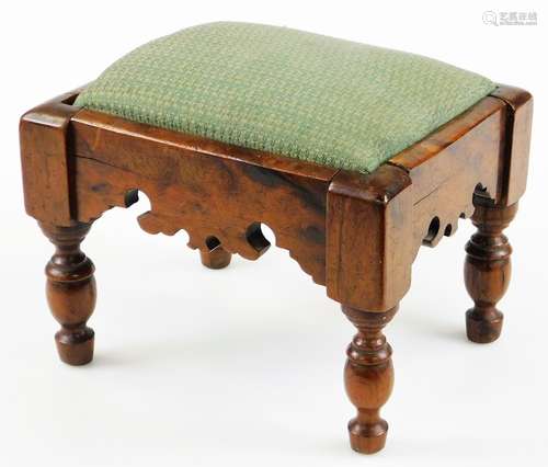 An early 19thC yew wood footstool, of rectangular form, with fretwork profiled frieze, on turned