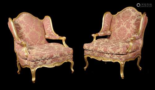 Two similar French giltwood wing armchairs