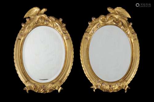 A pair of French carved giltwood oval mirrors