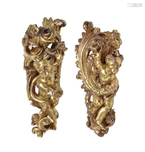 A pair of carved giltwood and gesso models of seated cherubs