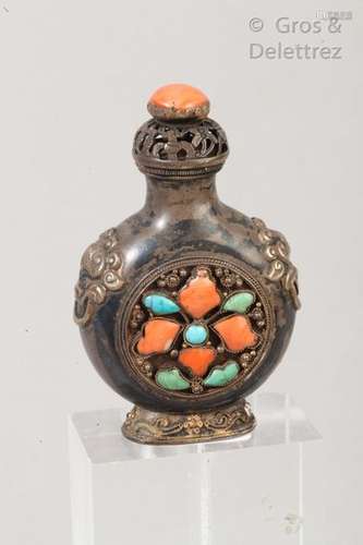 Flacon tabatière de forme gourde sur piédouche en métal orné de têtes de lion, à décor en médaillon du joyau bouddhique en corail et turquoise. Chine, XIXe siècle. H : 6,5 cm.                                                                                                                                                                                                                                                                                                                         估价            120 - 150 EUR                                                                                                                                                                * 不计佣金。