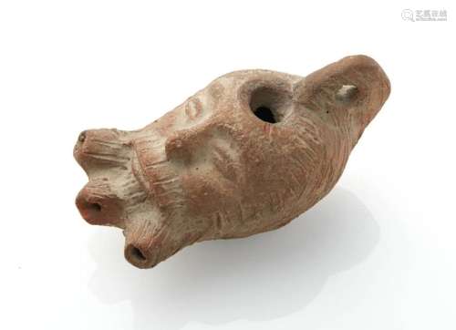 Old terracotta oil lamp representing a face. Old R…