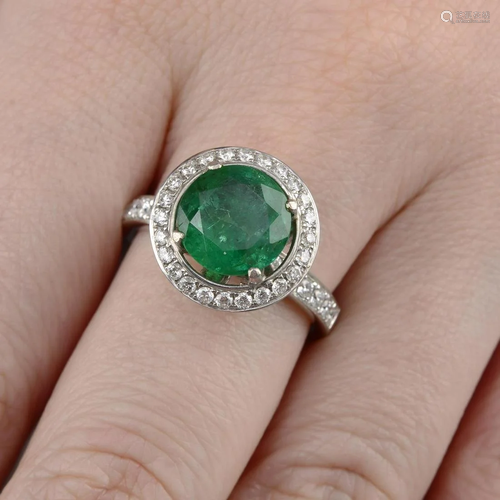 An 18ct gold emerald and brilliant-cut diamond halo