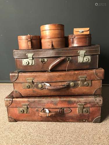 A group of three early 20th Century leather suitcases,