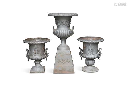 Three large cast iron Campagna style urns with handles of similar design,