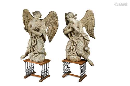 A large and imposing pair of carved and painted angels, probably late 17th century,