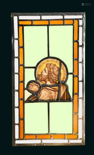 An 18th century stained glass section of a praying saint,