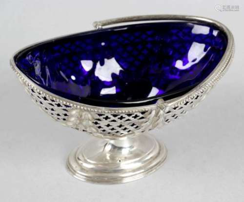 An Edwardian silver pedestal sugar basket with swing handle and blue glass liner,