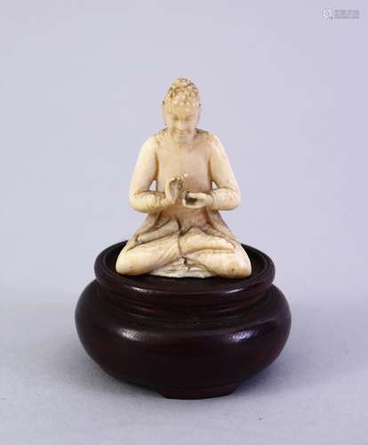 A SMALL 19TH CENTURY CARVED INDIAN IVORY FIGURE OF A DEITY, on a wooden base, 5cm.