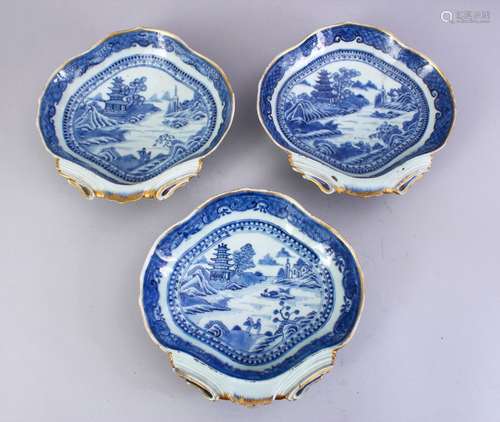 THREE 18TH CENTURY CHINESE BLUE & WHITE PORCELAIN SHELL DISHES, the dishes with gilded landscapes,