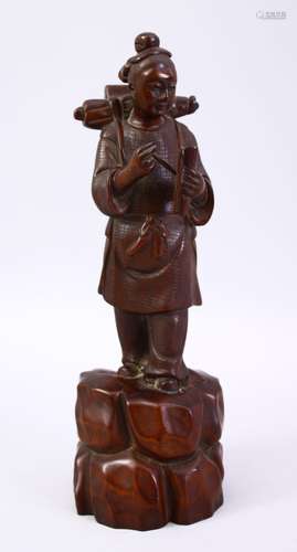 A JAPANESE MEIJI PERIOD CARVED WOODEN OKIMONO OF A TRAVELLING BOY, the boy wearing his pack pack and