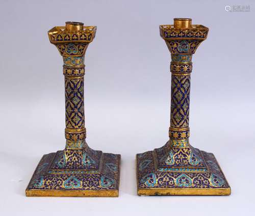 A GOOD 19TH CENTURY INDIAN KASHMIRI GILT & ENAMEL CANDLESTICKS, the sticks with enamel decoration