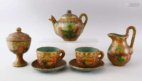 AN UNUSUAL INDIAN PAPIER MACHE TEA SET, consisting of two cups and saucers, a tea pot, coffee pot