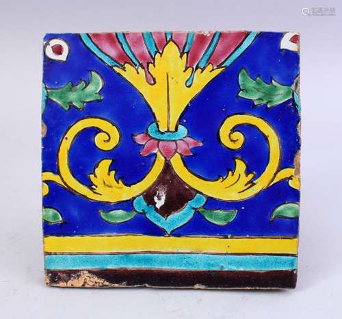 A 19TH CENTURY PERSIAN QAJAR GLAZED POTTERY TILE, with polychromed decoration, 19.5cm wide.