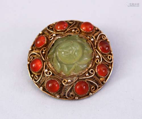 A GOOD INDIAN SILVER GILT & JADE BROOCH, with filigree work enclosing a floral carved jade centre,