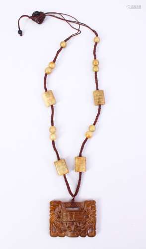 A CHINESE CARVED JADE OR HARD STONE PENDANT & BEADS, all attached as part of a necklace, with carved