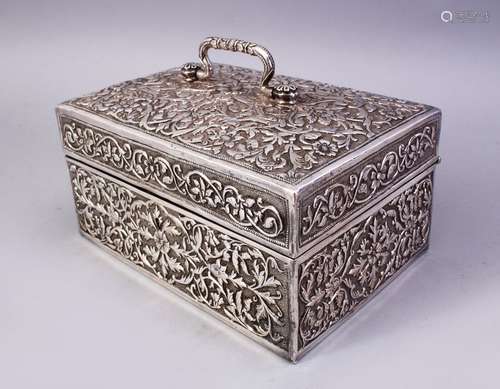 A FINE 19TH CENTURY INDIAN CUTCH SILVER CASKET, the hinged lid and body profusely embossed and