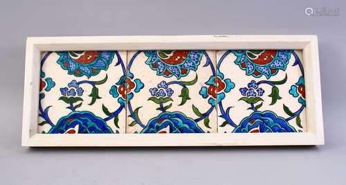 THREE FRAMED IZNIK POTTERY TILES, each with a display of flora, framed 49cm x 18cm.