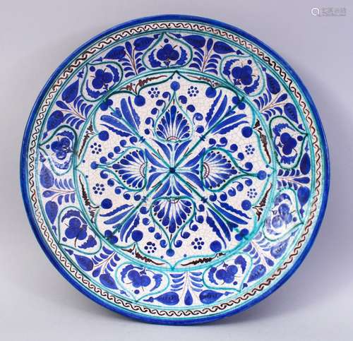 A PERSIAN OR CENTRAL ASIAN POTTERY CIRCULAR DISH, painted with stylised decoration, Iznik style,