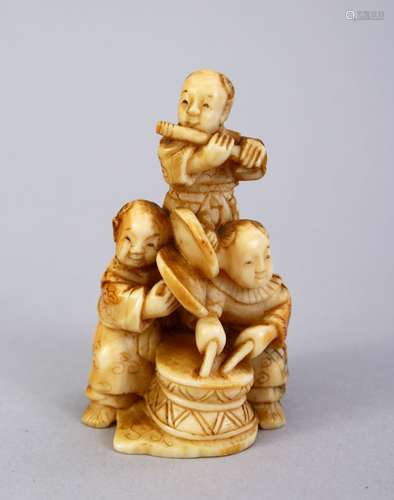 A JAPANESE MEIJI PERIOD CARVED IVORY NETSUKE OF THREE BOYS, the three boys stood each playing an