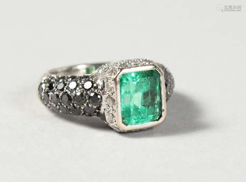 A VERY GOOD 18CT WHITE GOLD AND EMERALD RING, with diamond and sapphire shanks.