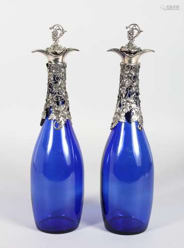 A GOOD PAIR OF BRISTOL BLUE GLASS DECANTERS, with fruiting vine mounts. 12ins high.