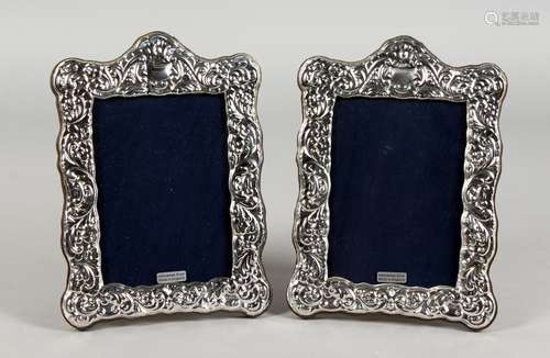 A PAIR OF EMBOSSED SILVER PHOTOGRAPH FRAMES. 7.5ins x 5.75ins.