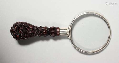 A SMALL MAGNIFYING GLASS with carved handle.