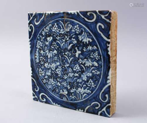 A GOOD CHINESE MING STYLE BLUE & WHITE TILE, decorated with flora, 20cm square.
