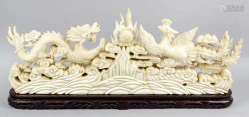 An oriental carved marble ornament modelled as a dragon and phoenix flanking a flaming pearl,