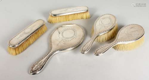 A FIVE PIECE ENGRAVED SILVER DRESSING TABLE SET, comprising hand mirror and four brushes. London