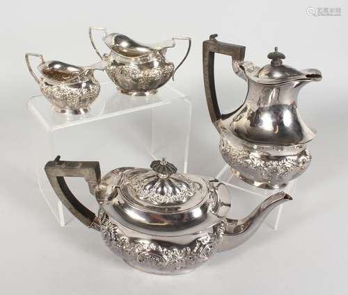 A FOUR PIECE EDWARDIAN SILVER TEA SET, with repousse decoration, comprising teapot, hot water jug,