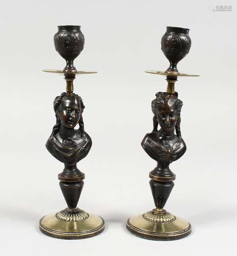 A PAIR OF BRONZE AND METAL CANDLESTICKS, depicting a bust of a lady, on circular bases. 10ins high.