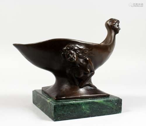 AN UNUSUAL ART DECO DESIGN BRONZE CUP, with mask handle, on a marble base. 12ins long.