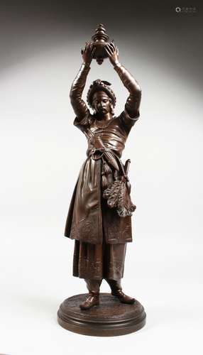 A 19TH CENTURY BRONZE FIGURE OF A TURKISH MAN holding aloft a vessel, on a circular base. 23ins