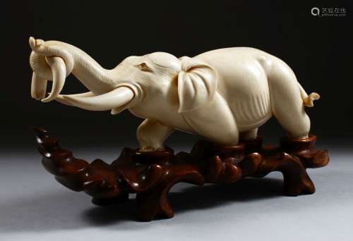 A 19TH CENTURY CHINESE CARVED IVORY FIGURE OF AN ELEPHANT, the elephant holding on to the horn of
