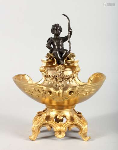 A GILT BRONZE TABLE SALT, modelled as a cherub seated on a shell. 7.5ins high.