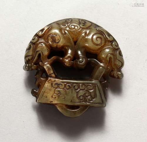 A CHINESE JADE PENDANT, carved with a double headed mythological beast. 2ins wide.