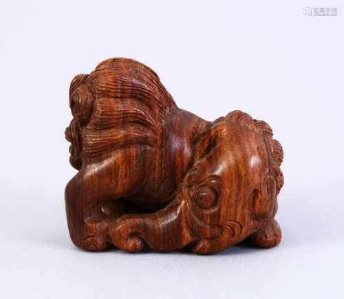 A JAPANESE MEIJI PERIOD STYLE CARVED WOODEN NETSUKE OF A LION ELEPHANT, the lion dog with an