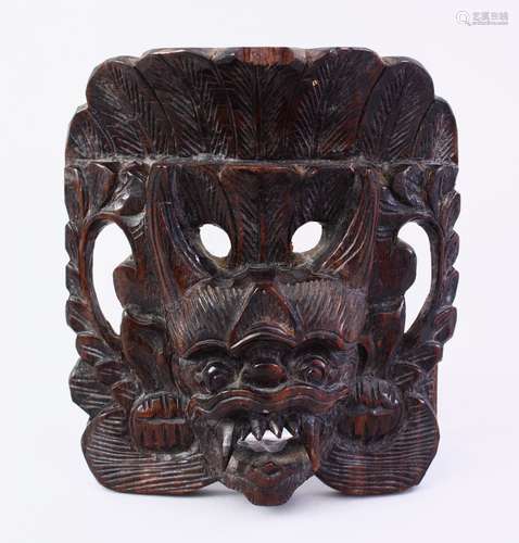 AN ORIENTAL CARVED HARDWOOD MASK, 13CM