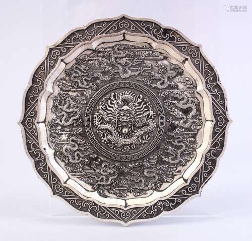 A CHINESE WHITE METAL DRAGON DISH, decorated with many dragons amongst clouds, 12cm.