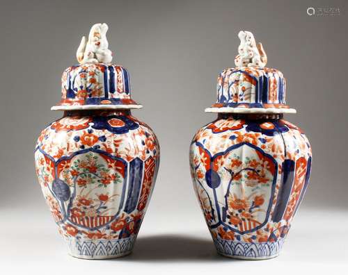 A PAIR OF JAPANESE IMARI VASES AND COVERS. 12ins high.