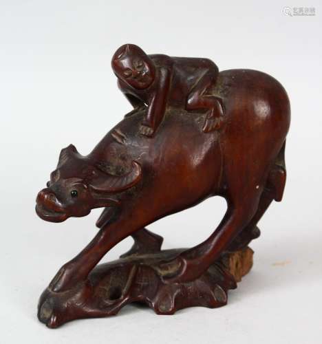 A 19TH CENTURY CHINESE CARVED CHERRYWOOD FIGURE OF AN OXEN & BOY, the boy riding upon the back of