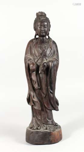 A CHINESE CARVED HARDWOOD FIGURE OF GUANYIN. 20ins high.