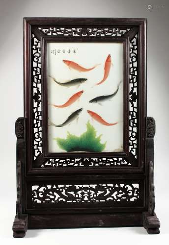 A CHINESE HARDWOOD AND PORCELAIN TABLE SCREEN, the panel painted with koi carp. 26ins high x 18ins