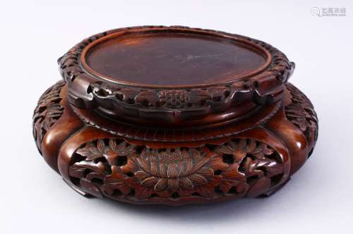 A GOOD 19TH CENTURY CHINESE CARVED HARD WOOD STAND, carved with sceens of flora, 32cm diameter ,