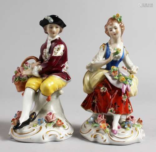 A PAIR OF SITZENDORF FIGURES, a seated man with basket of flowers, and a seated girl with a flower