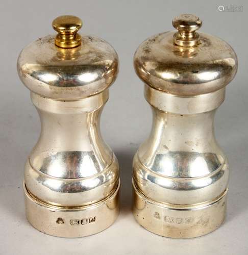 A PAIR OF SILVER SALT AND PEPPER GRINDERS. London 1986. 4ins high.