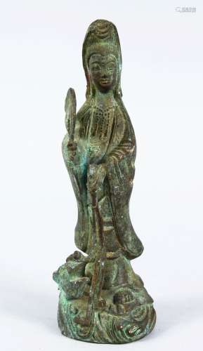 A GOOD EARLY CHINESE BRONZE FIGURE OF GUANYIN, stood with an emerging lion dog holding two