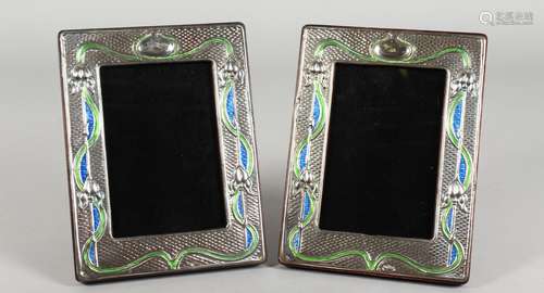 A PAIR OF ART NOUVEAU STYLE SILVER AND ENAMEL PHOTO FRAMES. 7.5ins high x 5.75ins.